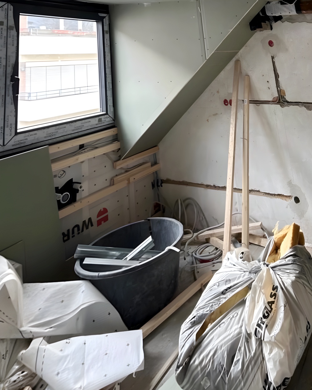 Vorher: Dachzimmer mit Gaube im Ausbau, offene Dämmung und Baumaterial